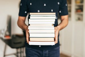 Person holding stack of books  karolina grabowska